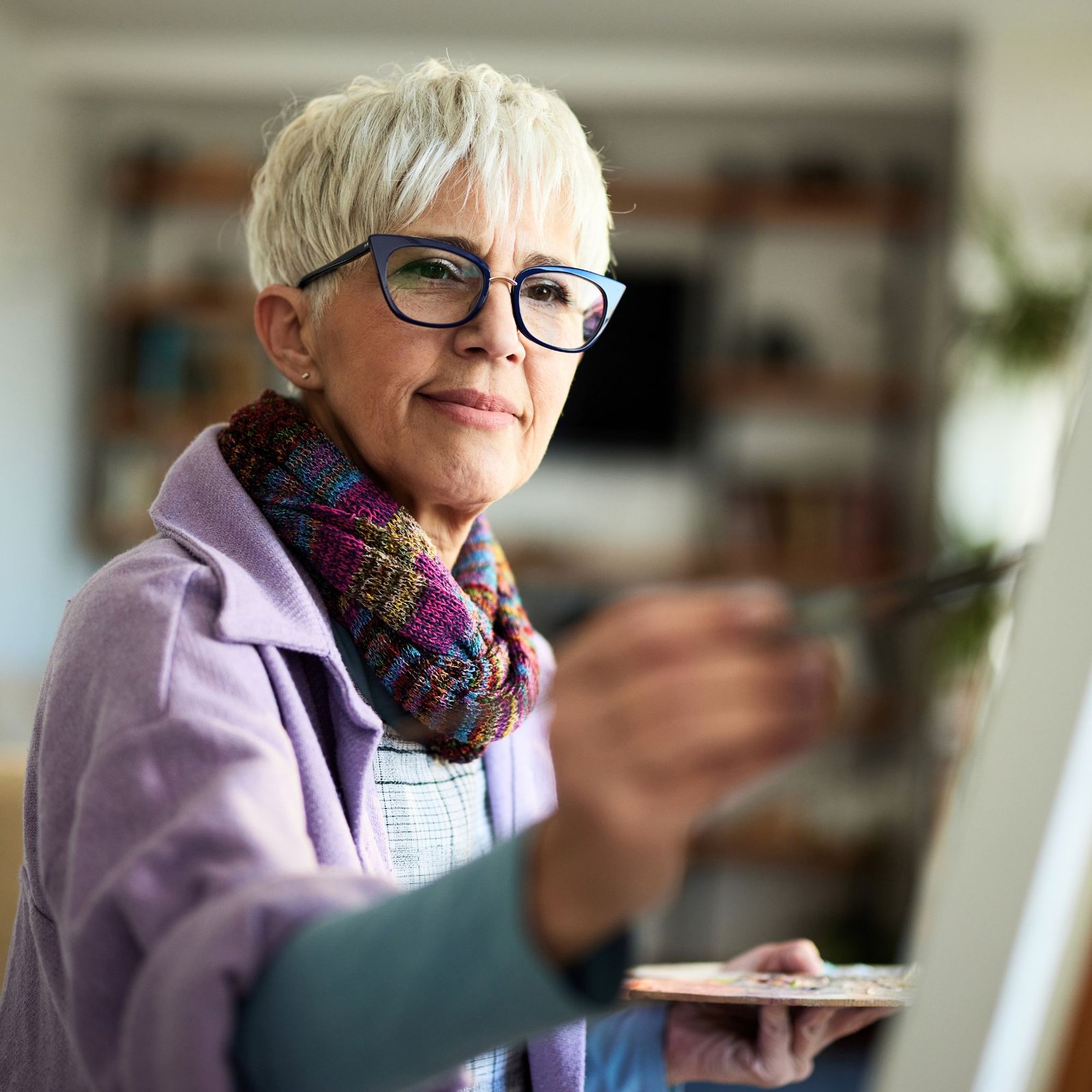 Retired woman enjoying painting during retirement after building long-term financial confidence through personalized financial planning.